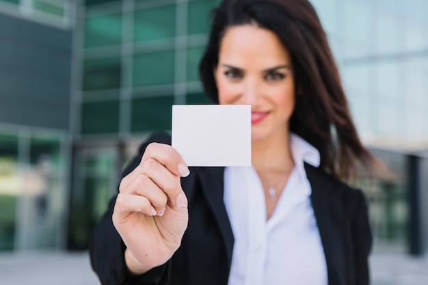 Mujer de negocios enseñando tarjeta de visita en blanco