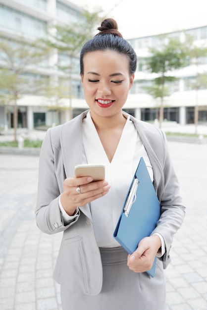 Mujer de negocios enviando mensajes de texto en el teléfono inteligente