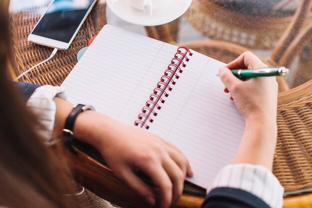 Mujer de negocios escribiendo en cafetería