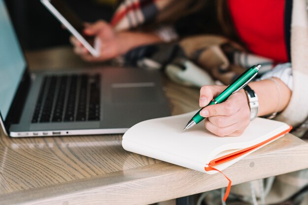 Mujer de negocios escribiendo en cafetería