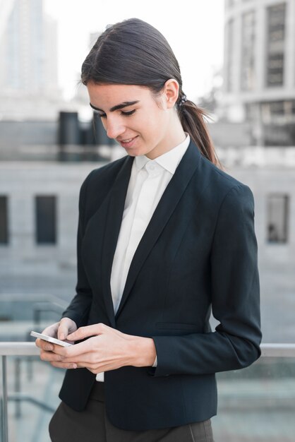 Mujer de negocios escribiendo en smartphone