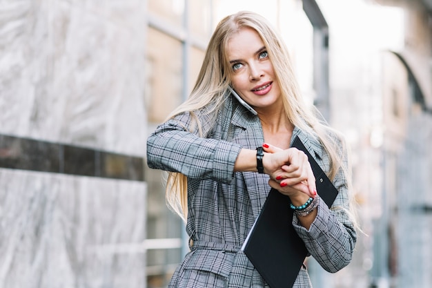 Mujer de negocios de estilo mirando a pulsera