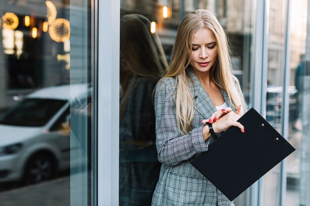 Mujer de negocios de estilo con portapapeles en ciudad