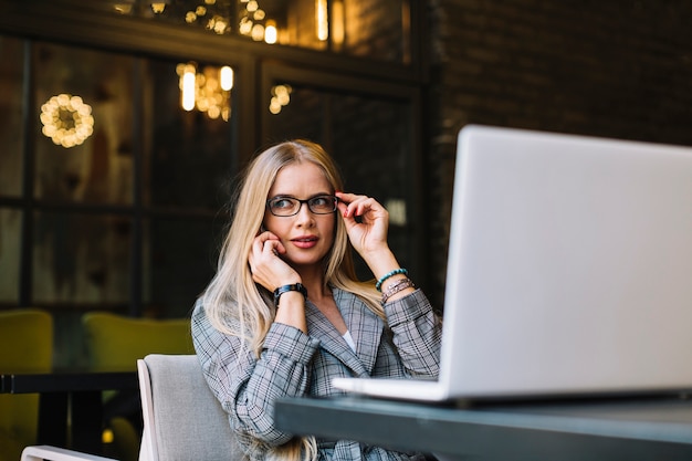 Foto gratuita mujer de negocios de estilo con portátil en cafetería agradable