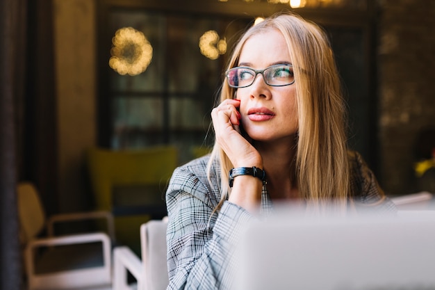 Mujer de negocios de estilo con portátil en cafetería agradable