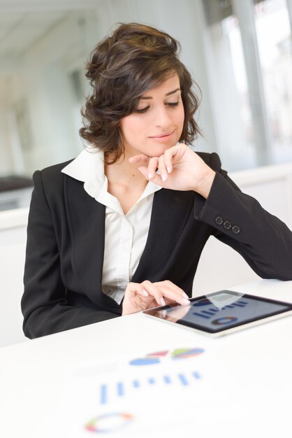 Mujer de negocios estudiando gráficos con su tableta