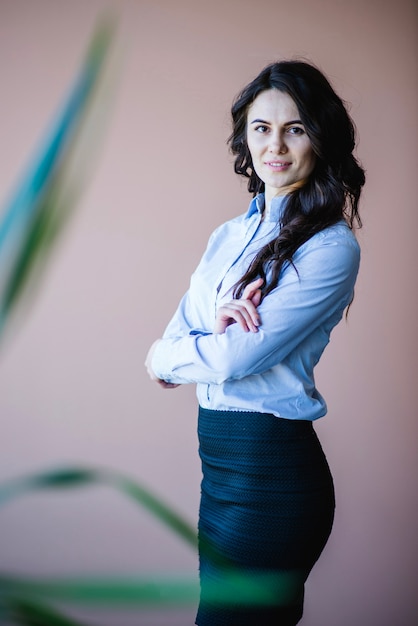 Mujer de negocios exitosa detrás de una planta