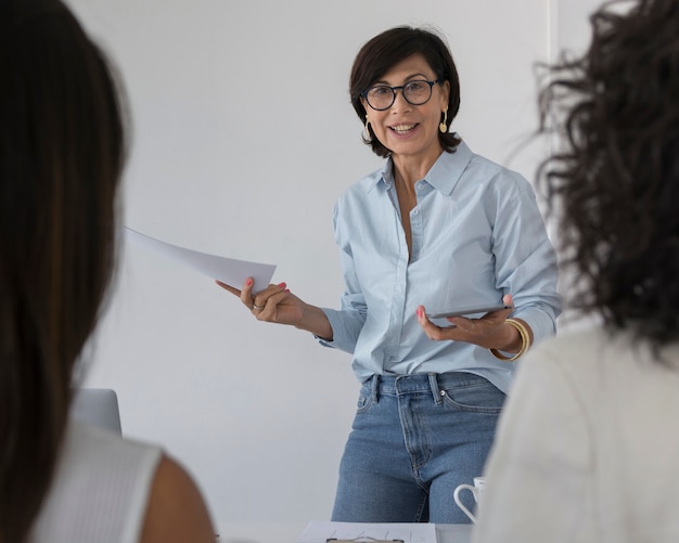 Mujer de negocios explicando algo a sus colegas