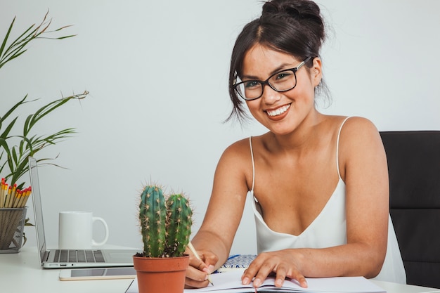 Foto gratuita mujer de negocios feliz con lápiz y cuaderno