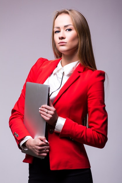 Mujer de negocios feliz con ordenador portátil sobre pared gris