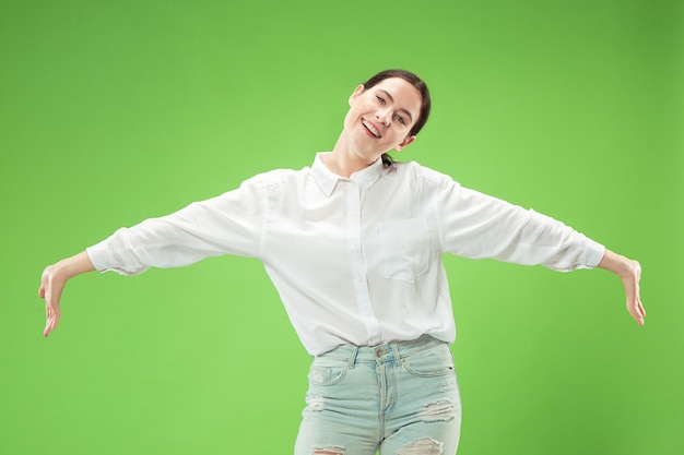 Mujer de negocios feliz de pie y sonriendo aislado en estudio verde