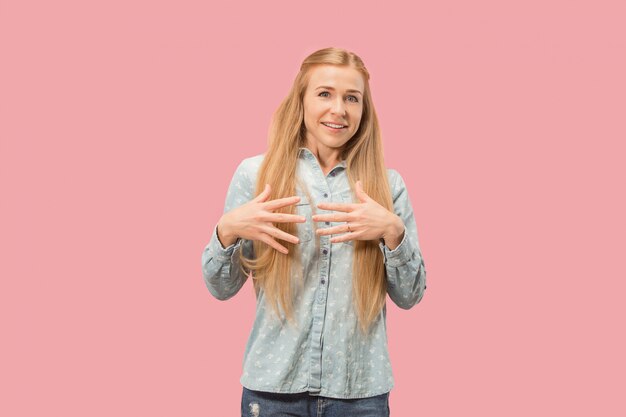 La mujer de negocios feliz de pie y sonriendo contra el espacio rosa.