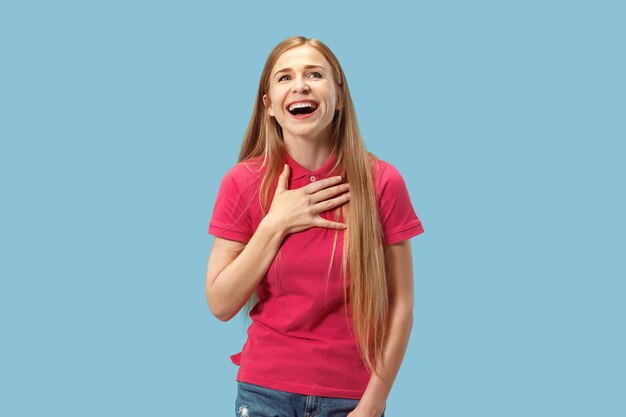 Mujer de negocios feliz de pie y sonriente aislado en estudio azul