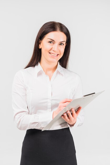 Mujer de negocios feliz que se coloca con el tablero