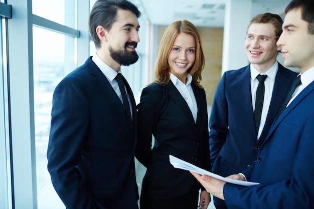 Mujer de negocios feliz rodeada de compañeros