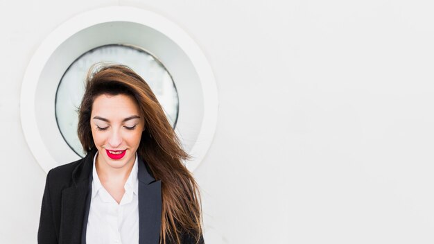 Mujer de negocios feliz en traje negro afuera