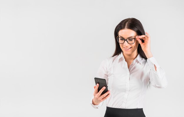 Mujer de negocios en gafas utilizando teléfono inteligente