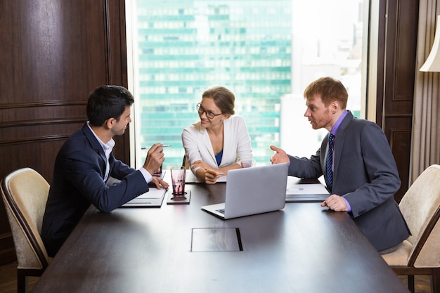 Mujer de negocios hablando con dos hombres de negocios