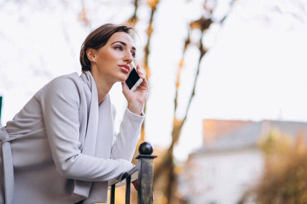 Mujer de negocios hablando por teléfono afuera