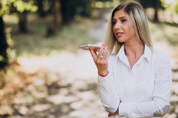 Mujer de negocios hablando por teléfono en el parque