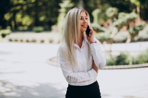 Mujer de negocios hablando por teléfono en el parque