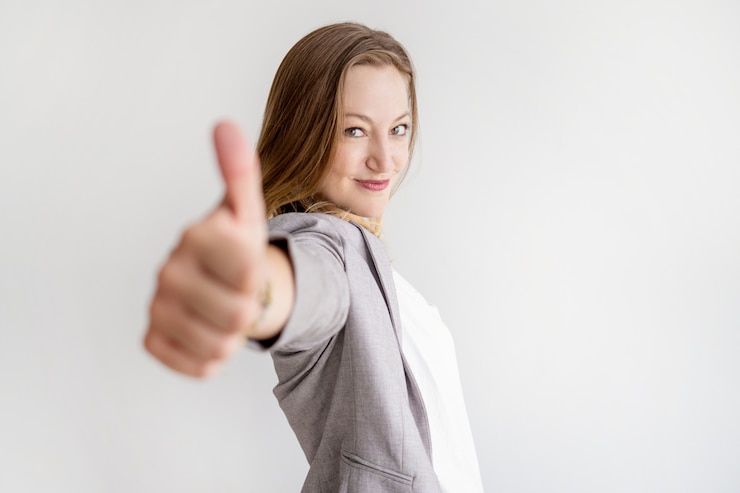 Foto gratuito mujer de negocios hermosa confiada que muestra el pulgar para arriba