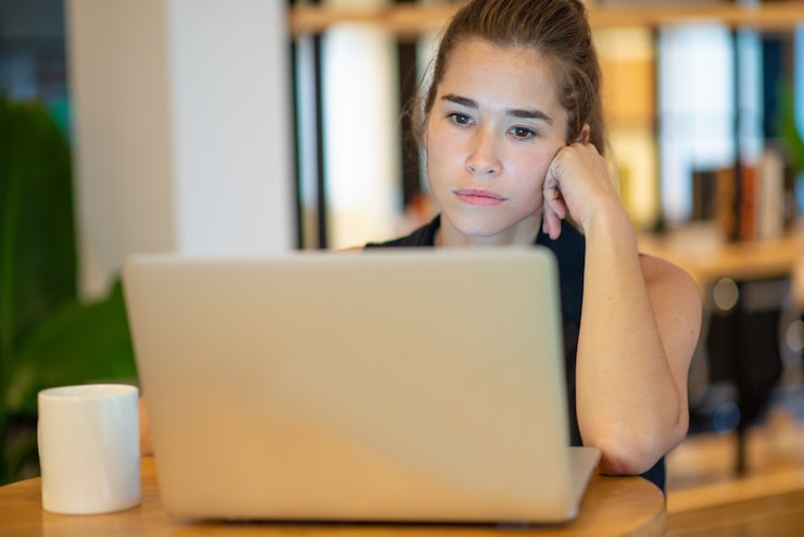 Foto gratuito mujer de negocios hermosa enfocada que trabaja en la computadora portátil.