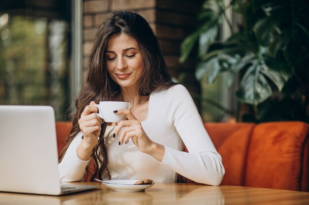 Mujer de negocios hermosa joven trabajando en equipo en un café