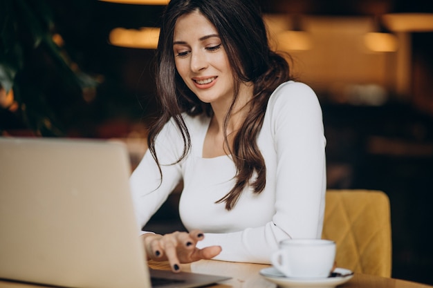 Foto gratuita mujer de negocios hermosa joven trabajando en equipo en un café