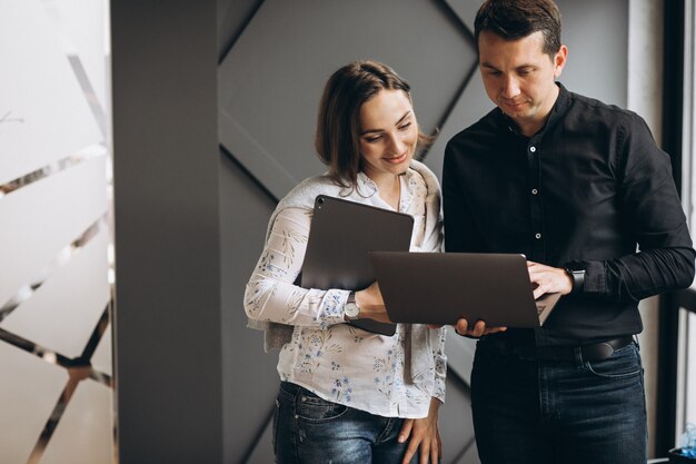 Mujer de negocios y hombre de negocios colegas que trabajan en la computadora portátil