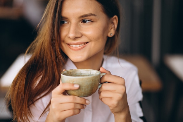 Foto gratuita mujer de negocios joven bebiendo café en un café