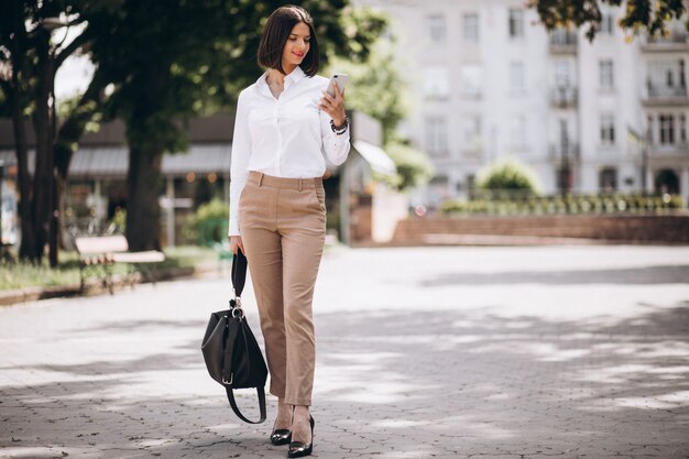 Mujer de negocios joven caminando en el parque