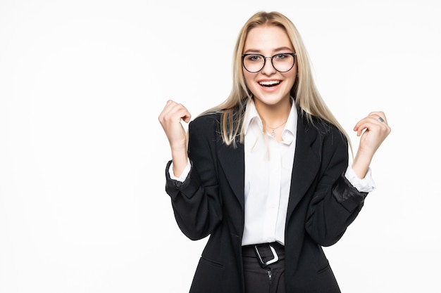 Mujer de negocios joven feliz haciendo gesto ganador, manteniendo los ojos cerrados posando aislado en la pared gris