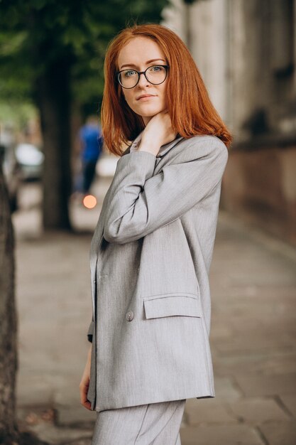 Mujer de negocios joven con pelo rojo al aire libre