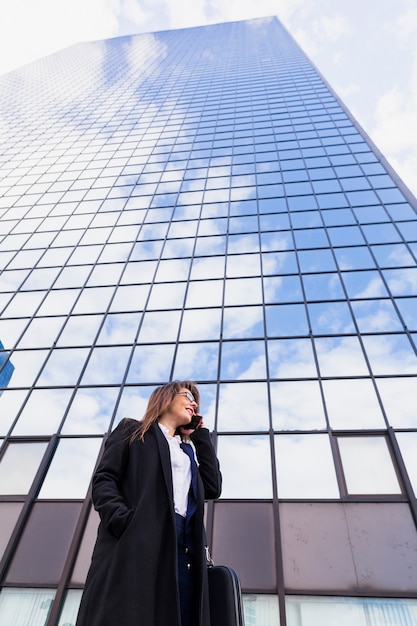 Foto gratuita mujer de negocios joven que habla por teléfono afuera