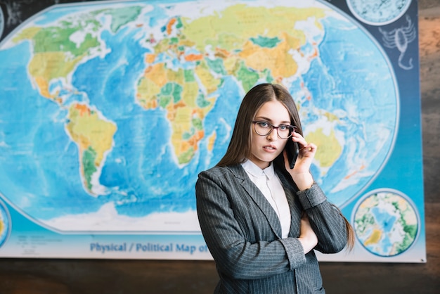 Foto gratuita mujer de negocios joven que habla por teléfono en oficina