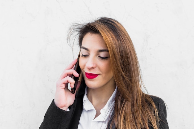 Mujer de negocios joven que habla por teléfono