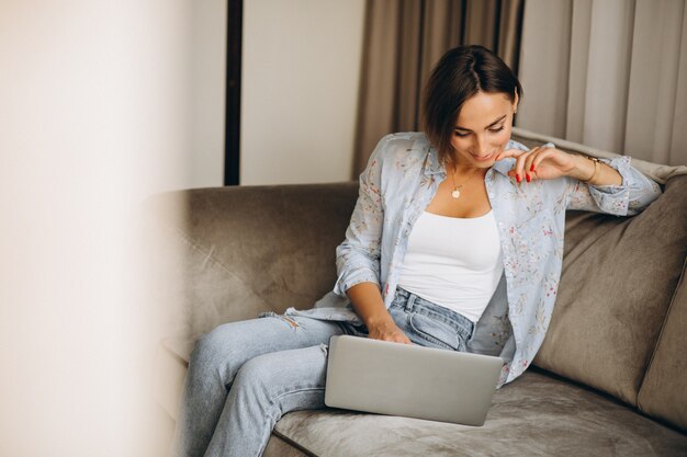 Mujer de negocios joven que trabaja en una computadora en casa