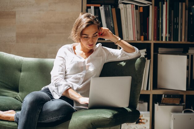 Mujer de negocios joven que trabaja en una computadora en casa