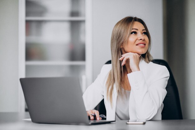 Mujer de negocios joven que trabaja en la computadora portátil en una oficina