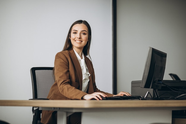 Mujer de negocios joven que trabaja en la computadora portátil en la oficina