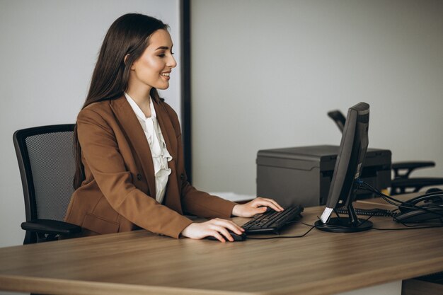 Mujer de negocios joven que trabaja en la computadora portátil en la oficina