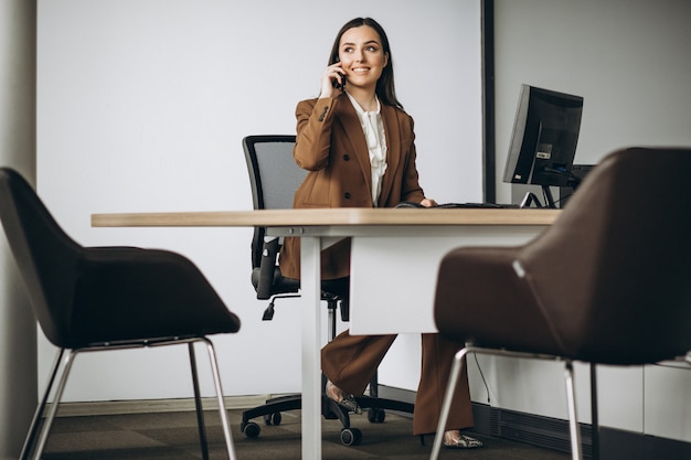 Mujer de negocios joven que trabaja en la computadora portátil en la oficina