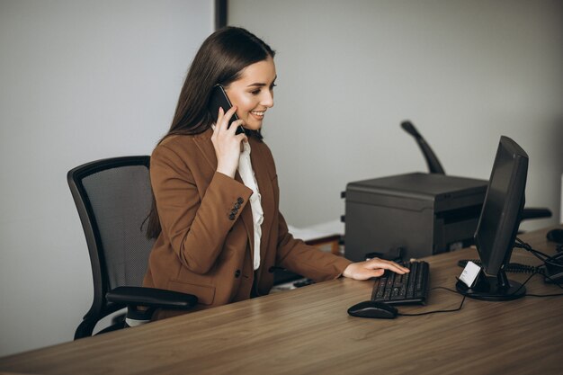 Mujer de negocios joven que trabaja en la computadora portátil en la oficina