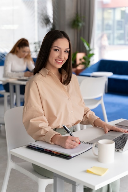 Mujer de negocios joven que trabaja en su escritorio con ordenador portátil