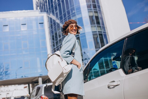 Mujer de negocios joven que viaja en coche eléctrico