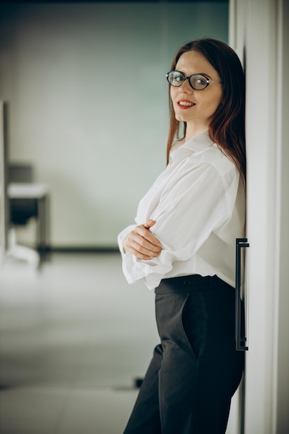 Mujer de negocios joven en ropa formal de pie en la oficina