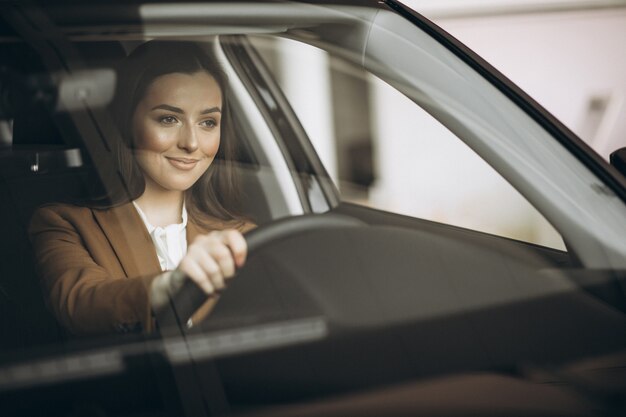 Mujer de negocios joven sentada en el coche