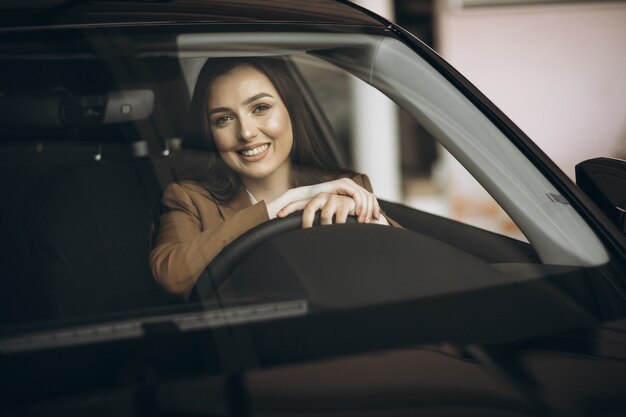 Mujer de negocios joven sentada en el coche