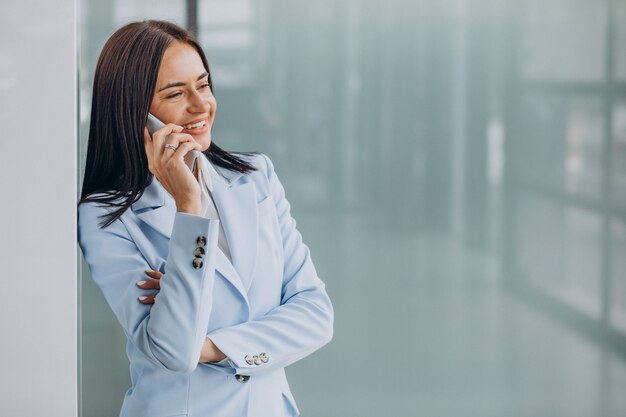 Mujer de negocios joven mediante teléfono móvil